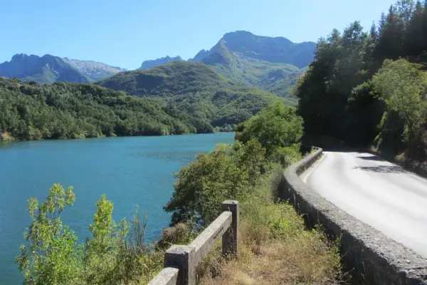 Strada panoramica sul lago, con montagne verdi sullo sfondo. Un viaggio verso il passo dei Carpinelli.